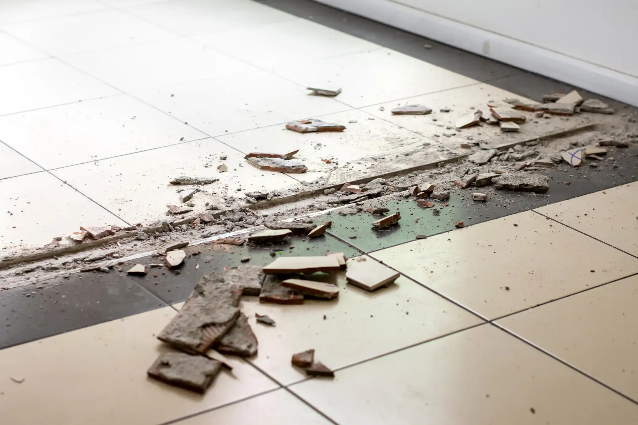 Cracked and lifting floor tiles showing visible gaps and damage